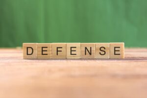 "DEFENSE" spelled out on wooden tiles, illustrating the concept.