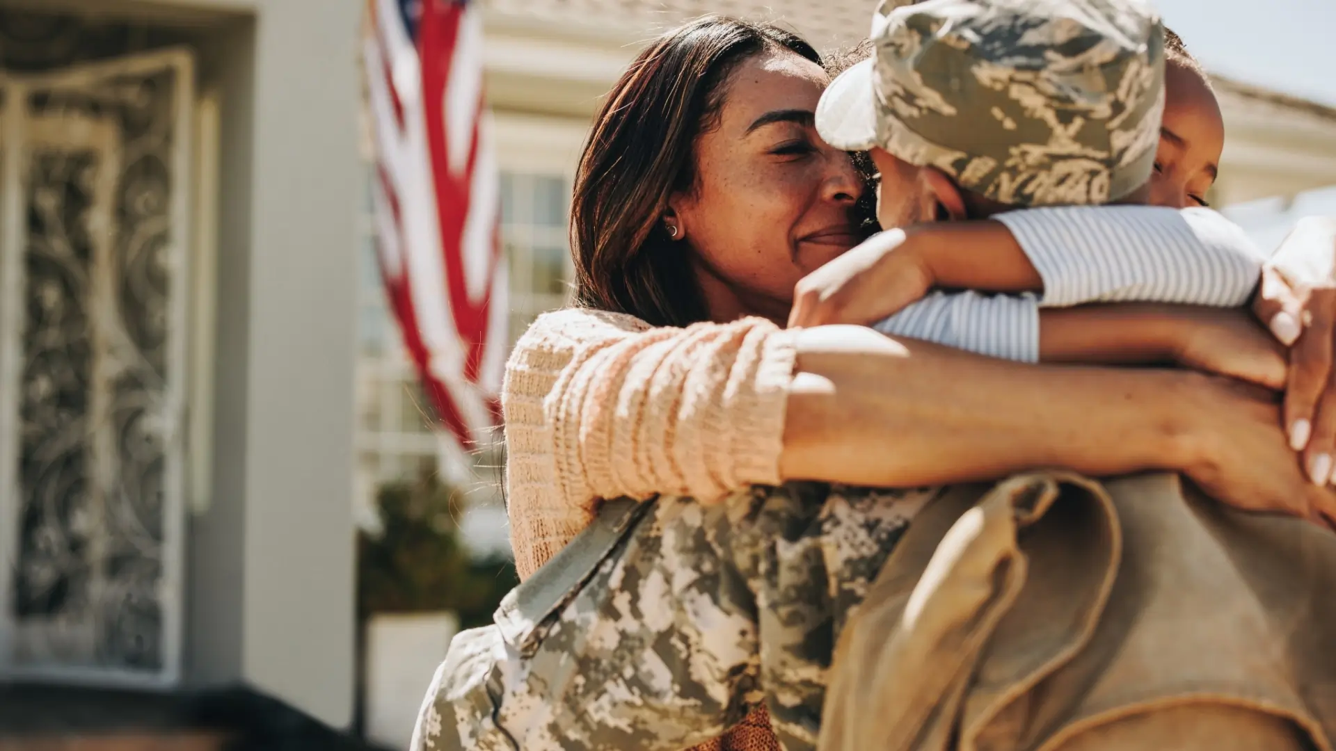 US service member embracing family members